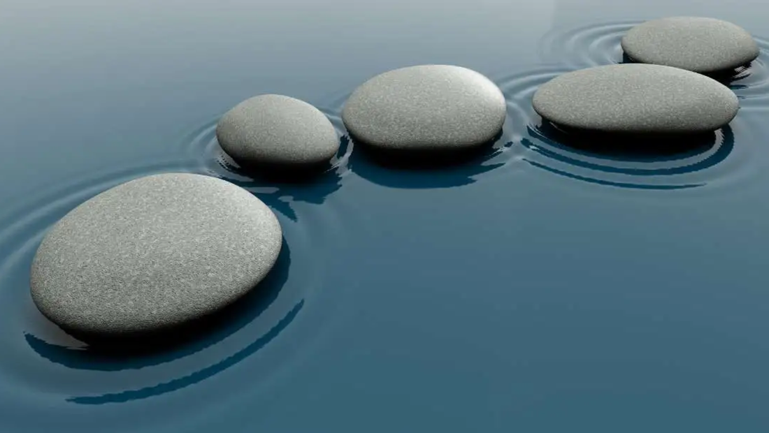 Smooth stones resting in calm water, symbolizing balance, relaxation, and gentle self-care during menstruation