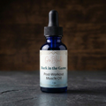 Bottle of 'Back in the Game' post-workout muscle oil with a dropper on a dark surface.