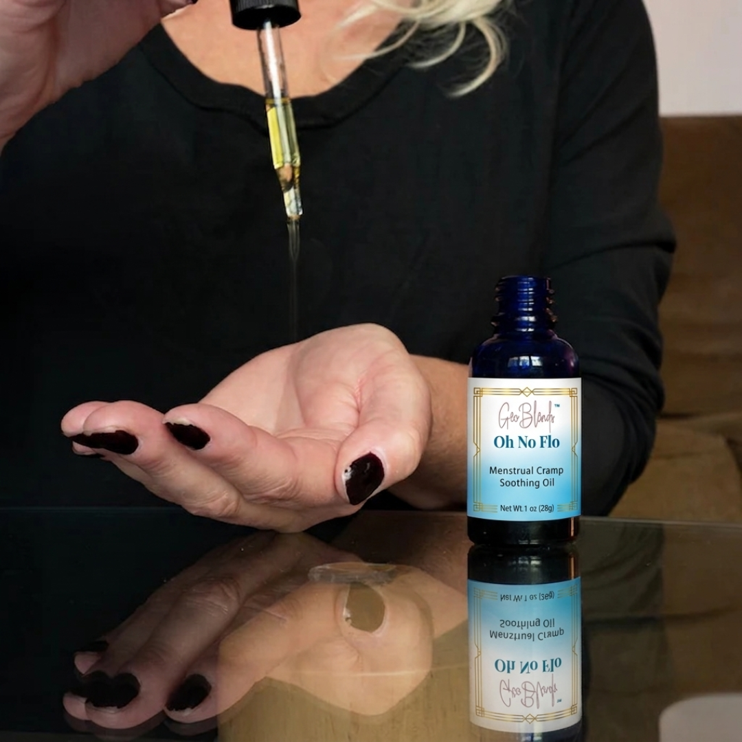 Bottle of 'Oh No Flo' menstrual cramp soothing oil with a dropper and reflection on a surface.
